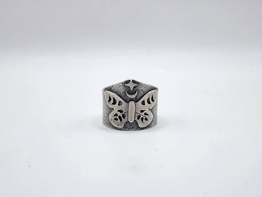 A sterling silver butterfly ring with a crescent moon and star at the top with a textured, oxidized finish, photographed on a plain white background.