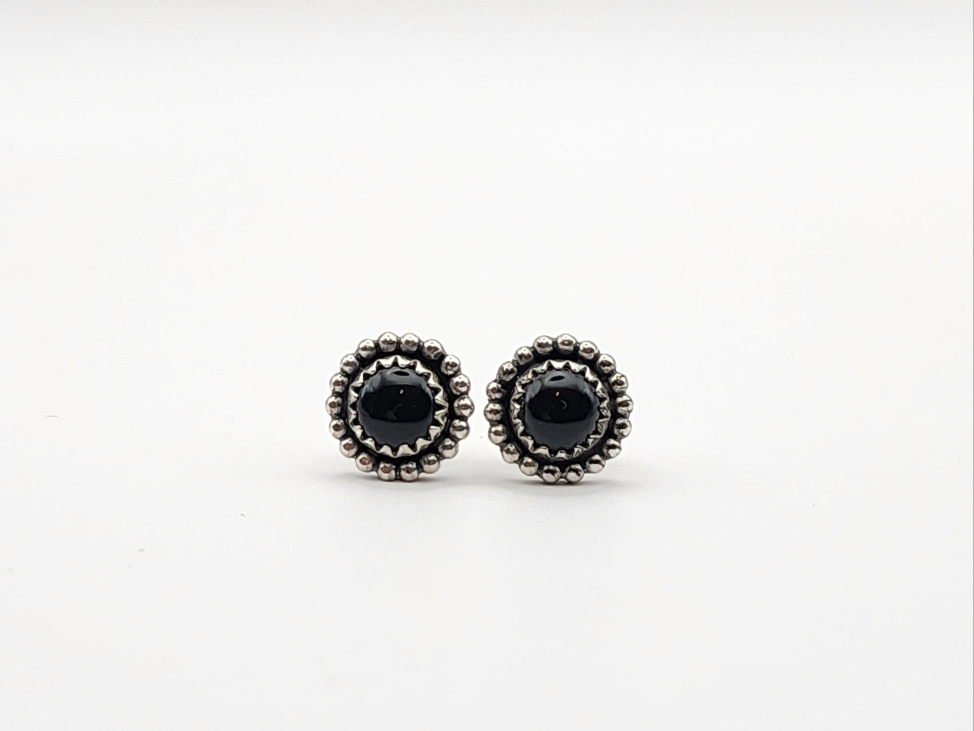 Pair of black onyx stud sterling silver earrings on a white background