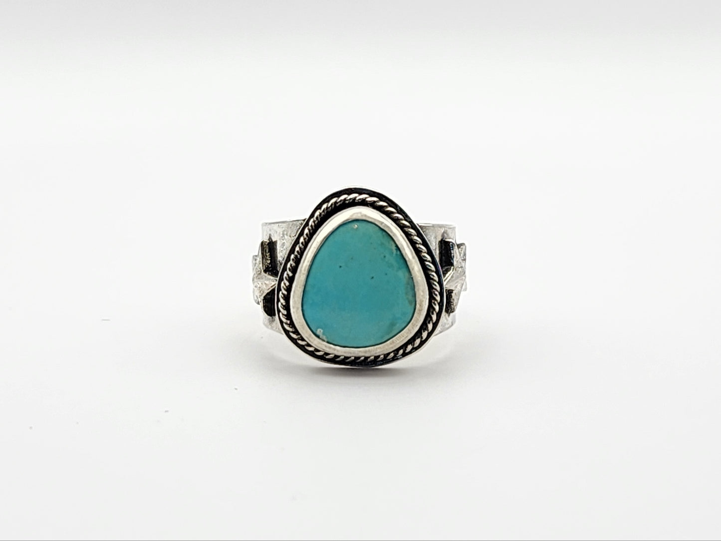 Front view of silver ring with a turquoise stone on a white background