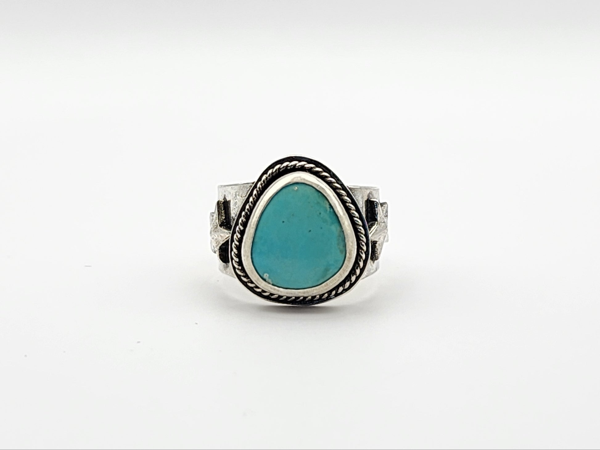 Front view of silver ring with a turquoise stone on a white background