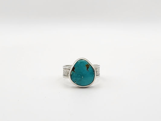 Ring with a turquoise stone and silver band on a white background